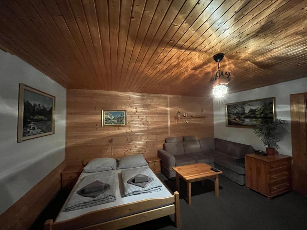ein Wohnzimmer mit einem Sofa und einem Tisch in der Unterkunft Chalupa u Porubäna in Liptovský Ondrej
