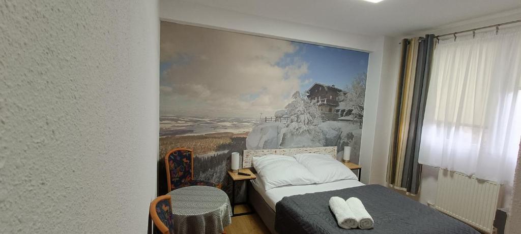 a bedroom with a bed with a painting on the wall at Jaśminowe Wzgórze in Polanica-Zdrój