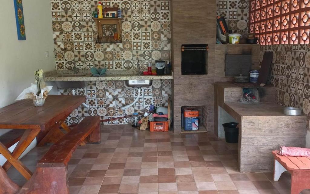 Habitación con mesa, bancos y pared. en Recanto dos Sonhos - Bocaina, en Dom Viçoso