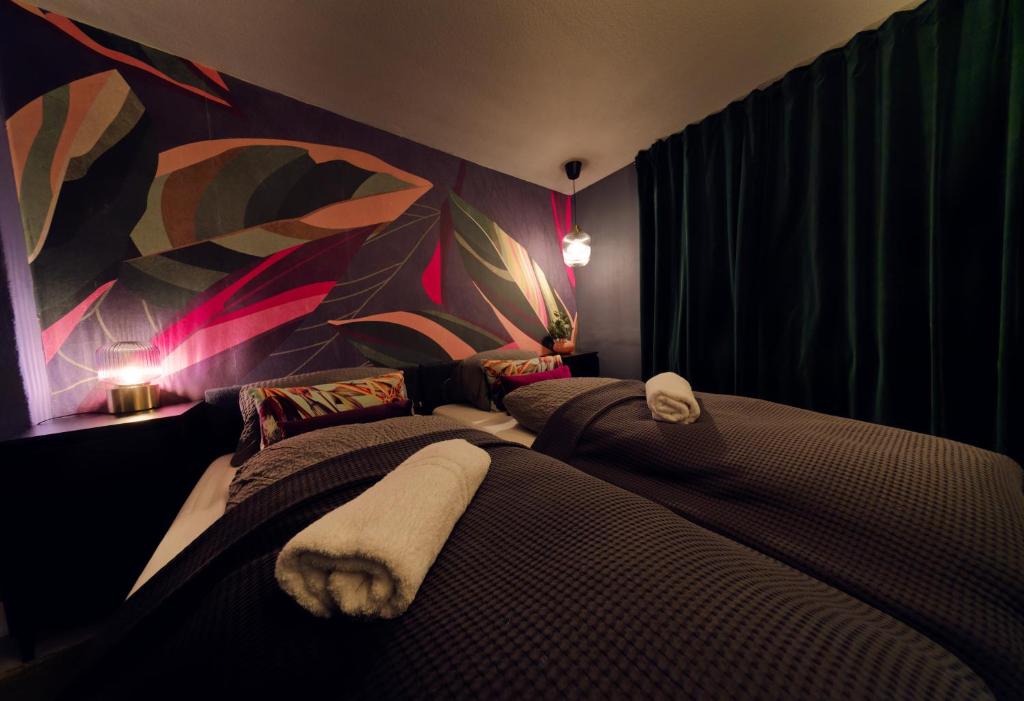 ein Schlafzimmer mit 2 Betten und einem Wandgemälde in der Unterkunft Reeperbahn Unique Boutique Apartments in Hamburg