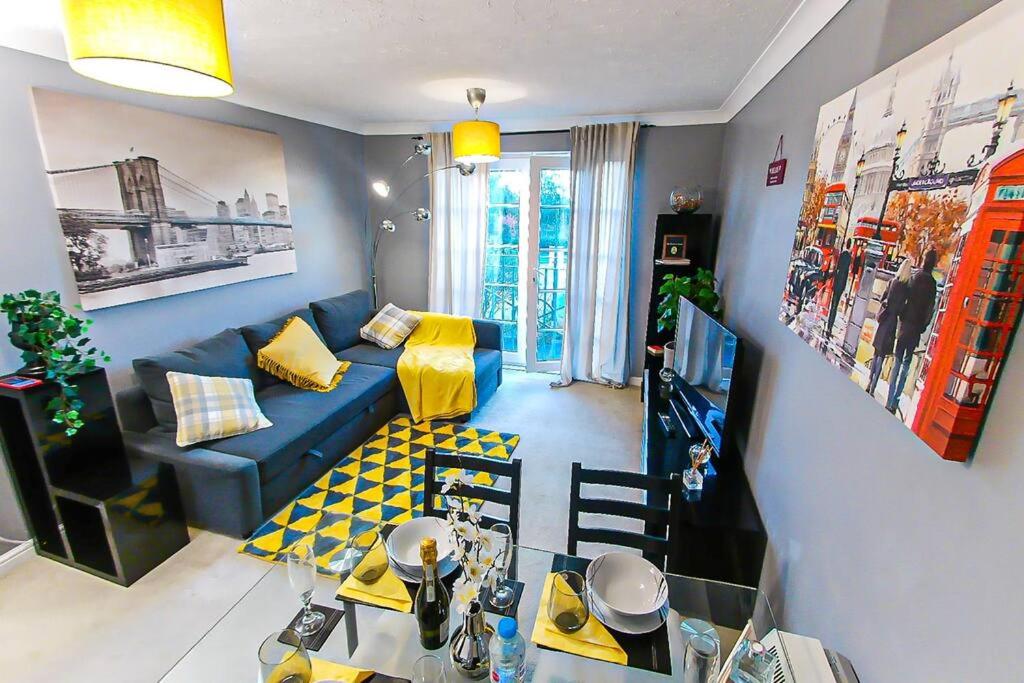 un soggiorno con divano blu e tavolo di Lovely apartment easy access to London a West Thurrock