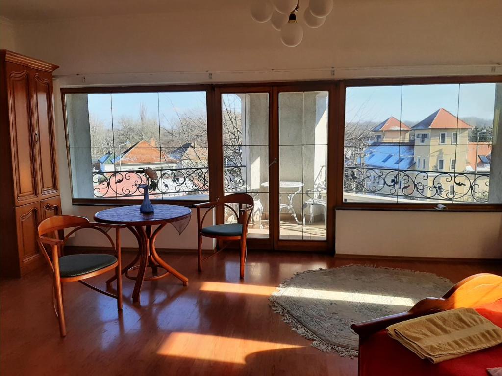 salon ze stołem i krzesłami oraz balkonem w obiekcie Magda Vendégház w Tokaju