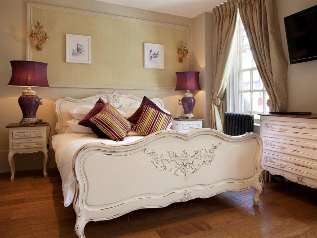 a bedroom with a white bed with pillows on it at No.64 at the Joiners in West Malling