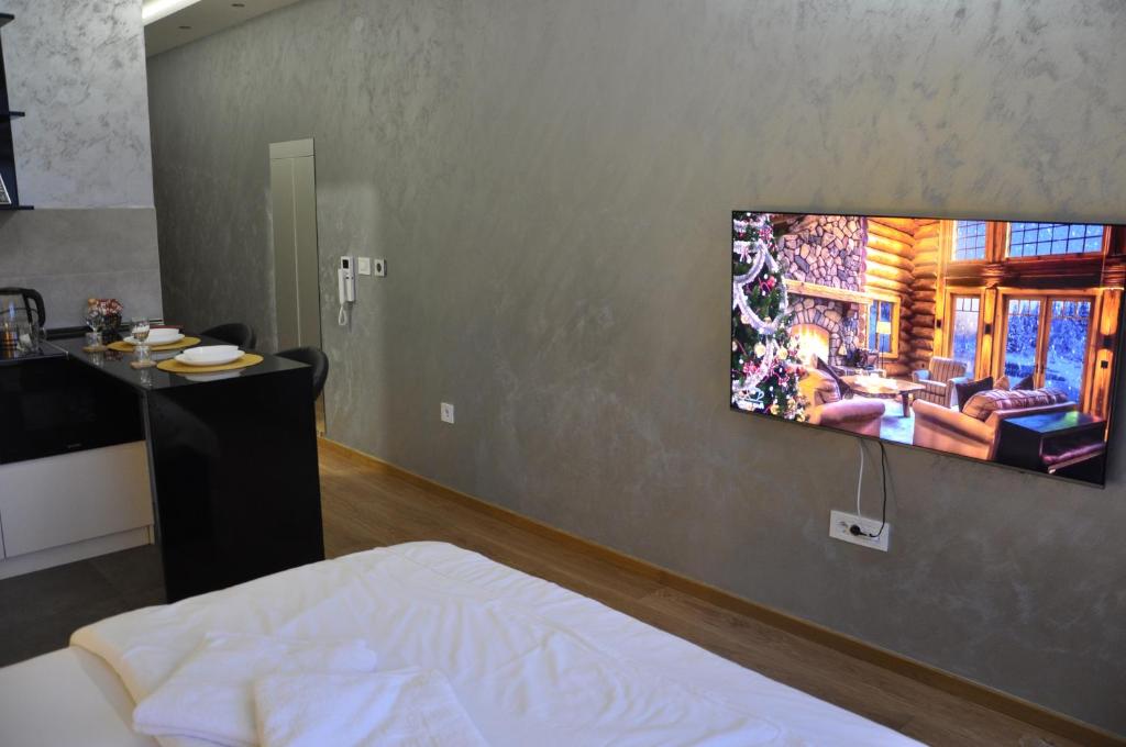 ein Schlafzimmer mit einem Bett und einem TV an der Wand in der Unterkunft Mali Princ Pupin Palace in Novi Sad