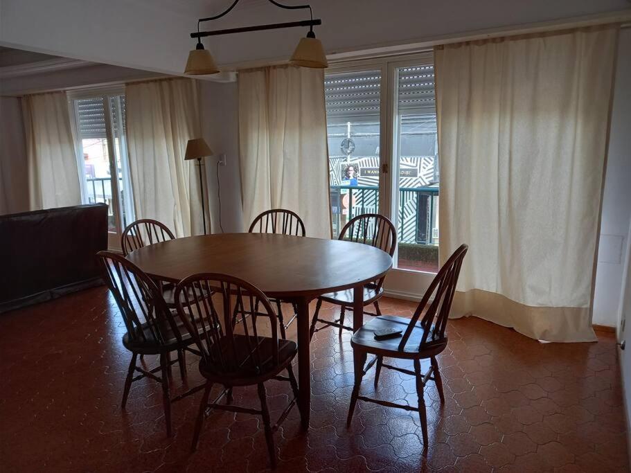 y sala de estar con mesa de comedor y sillas. en El Abedul-B-Departamento entero en pleno centro en Lobos