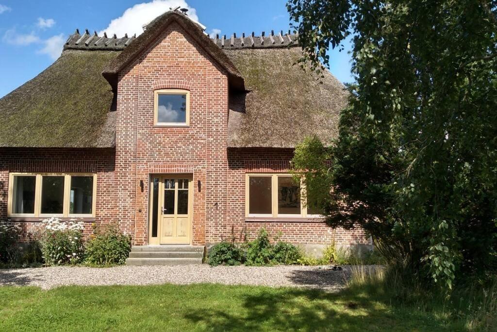 a brick house with a thatched roof at Erholung auf dem Land zwischen Ostsee und Schlei in Stoltebüll