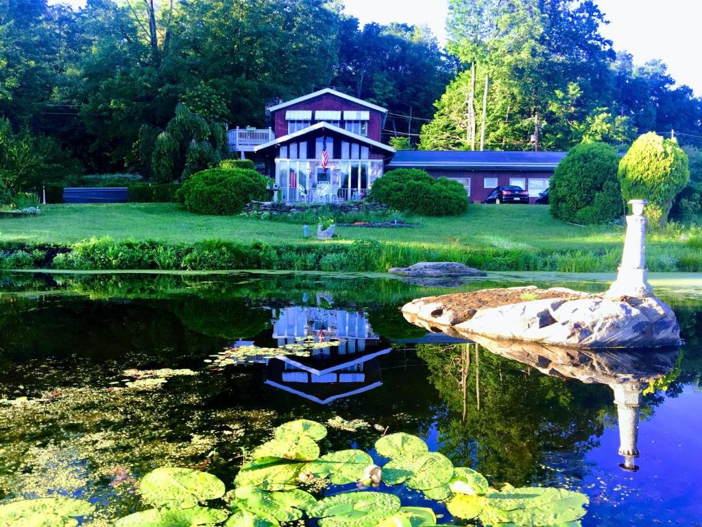 a house and a pond with a swan in front of it at Lake Moc A Tek Inn in Lakeville