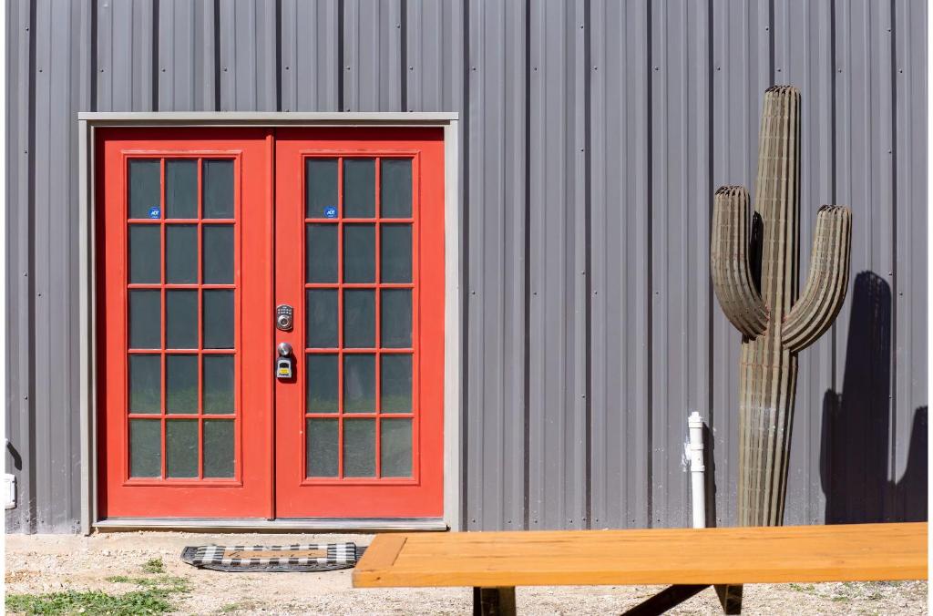 una porta rossa di fronte a un edificio con un cactus di Gorgeous Guesthouse Near Amazing Downtown a San Antonio