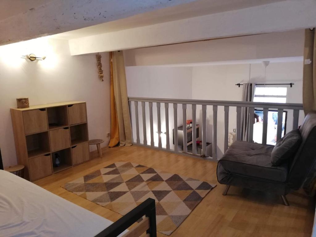 een slaapkamer met een bed, een bank en een balkon bij Le Cocon in Sète