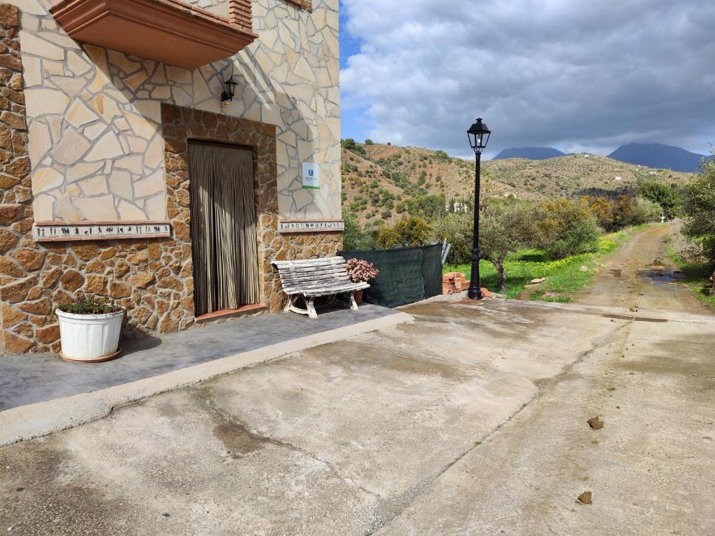 un banco sentado fuera de un edificio con ventana en Casa Rural Sierra De Las Nieves, en Tolox