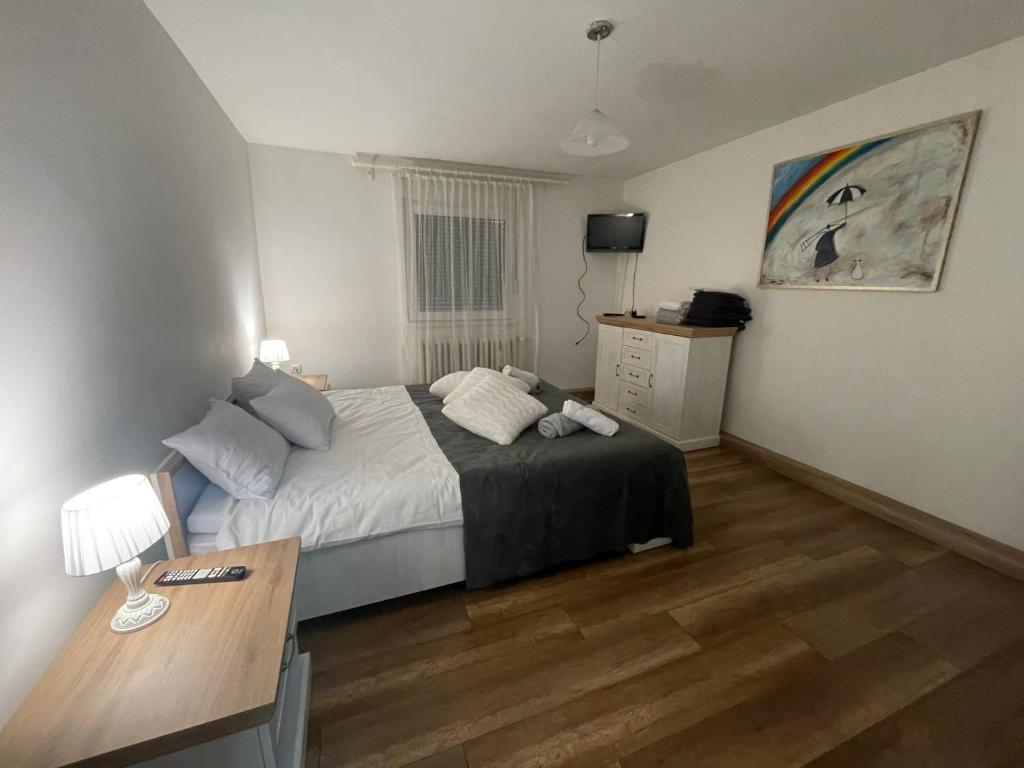 a bedroom with a bed and a desk in it at Antic Apartment in Požarevac