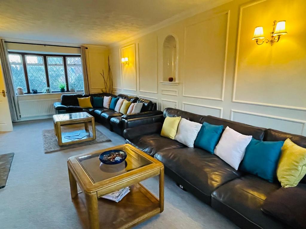 a living room with leather couches and a coffee table at Super King Bed Suite, Executive office, fast WiFi, free parking in St. Ives