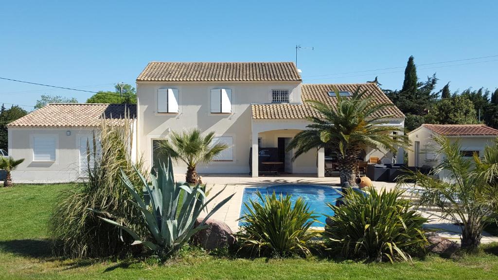 uma casa com piscina e palmeiras em Le studio du bonheur em Orange
