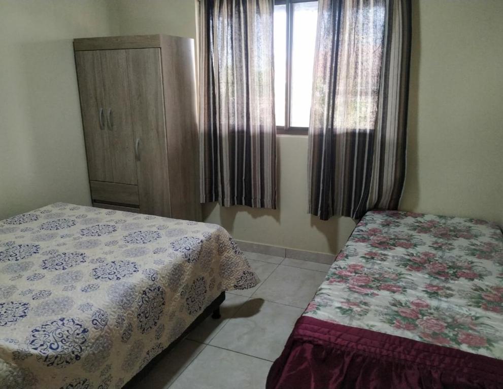 巴納內拉斯的住宿－Chalé Pôr do Sol，一间卧室设有两张床和窗户。