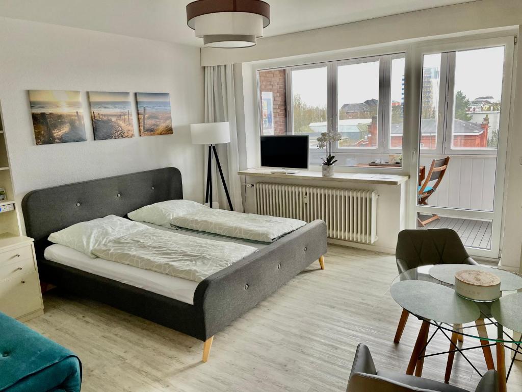 1 dormitorio con 1 cama y sala de estar en Wilhelms Havenkoje - gemütliches Innenstadtappartment, en Wilhelmshaven