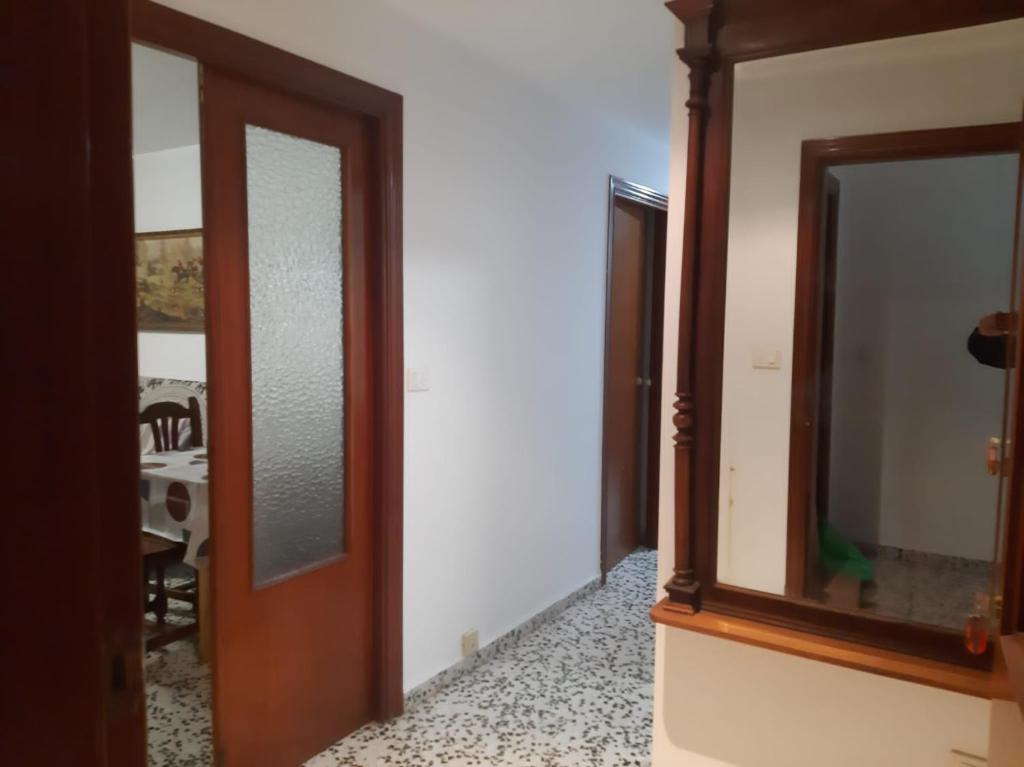 un couloir avec deux miroirs et une porte en bois dans l'établissement La Cruz Negra de Veruela, à Vera de Moncayo