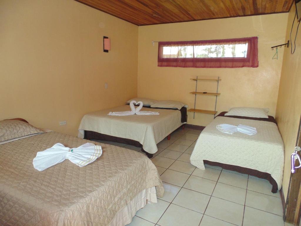 a room with two beds and a window at Cabinas Vista Miravalles in Bijagua