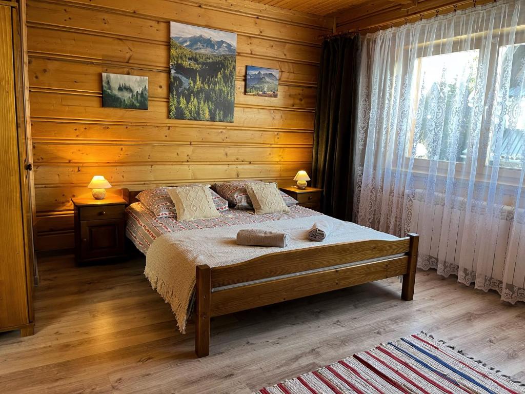 um quarto com uma cama num chalé de madeira em Jaworowe Izby em Bukowina Tatrzańska