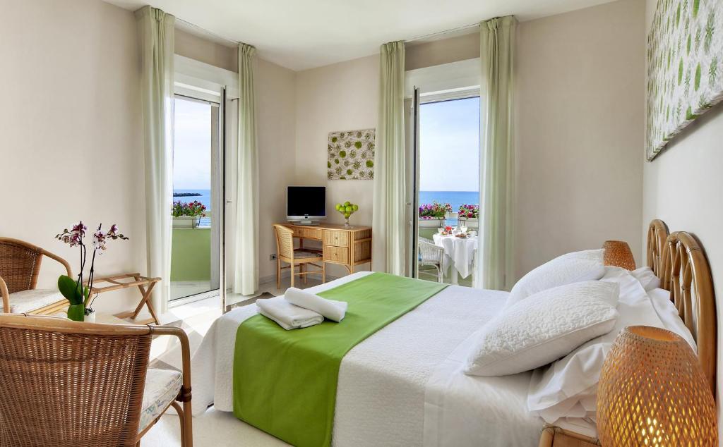 a bedroom with a bed with a view of the ocean at Hotel Mida in Scoglitti