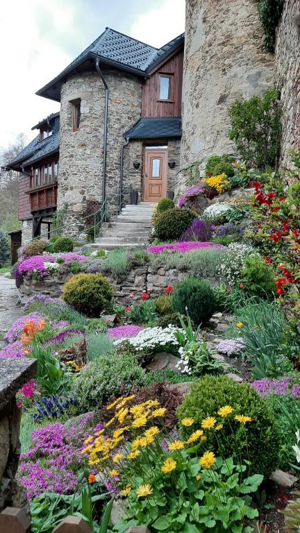 a garden with flowers in front of a house at Apartmán U Bašty in Vimperk