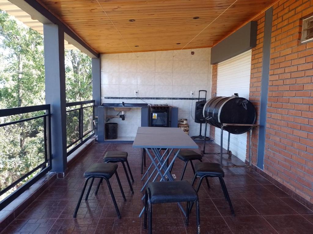 a kitchen with a table and chairs on a balcony at Hospedaje Los Laureles in Wanda