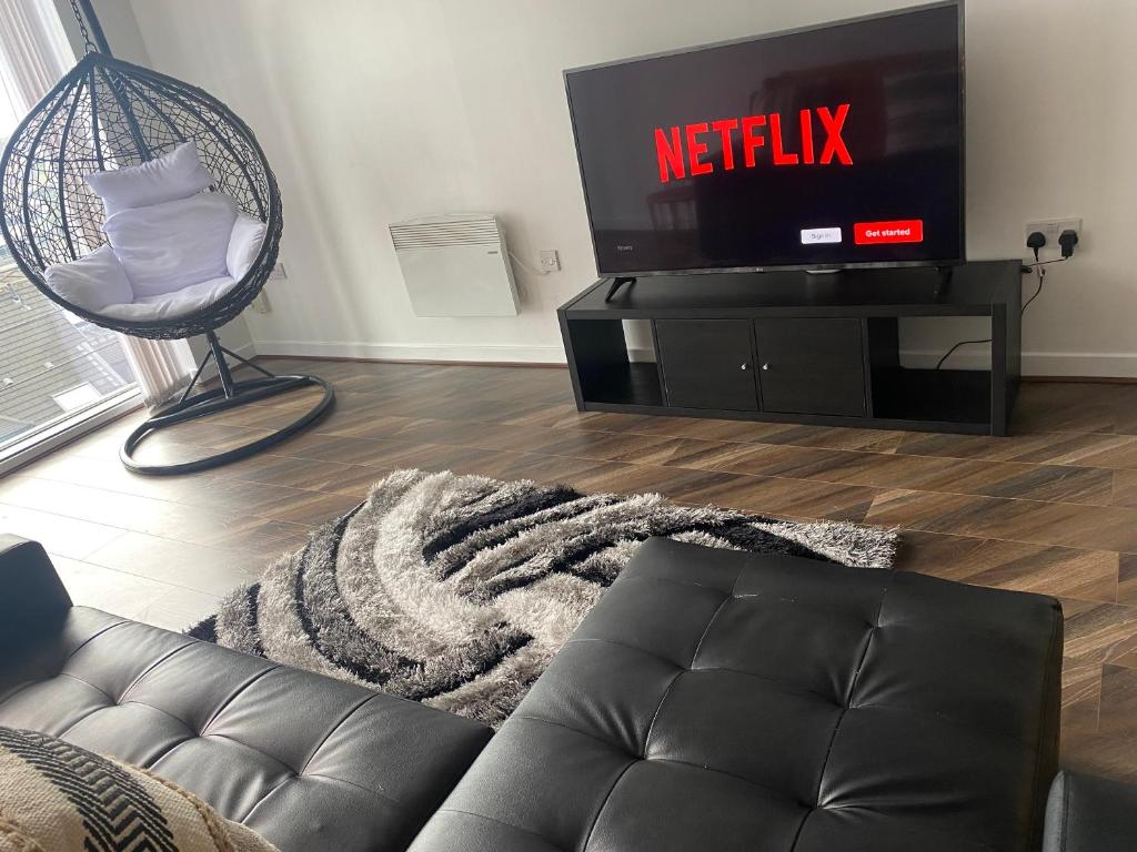 a living room with a couch and a tv at Modern 2-Bed Apartment in Glasgow SECC/HYDRO in Glasgow