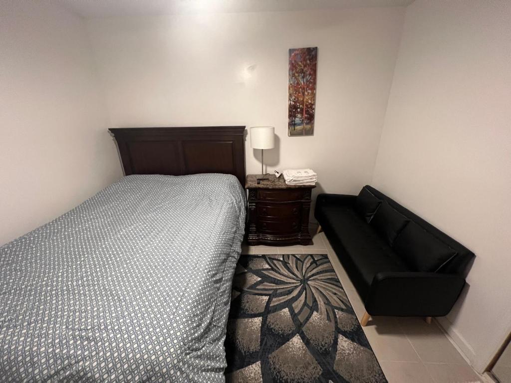 ein Schlafzimmer mit einem Bett und einem schwarzen Stuhl in der Unterkunft Lawn Residence in Brooklyn