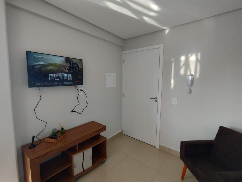 ein Wohnzimmer mit einem Flachbild-TV an der Wand in der Unterkunft Happy Apartamentos Unidade 2 in Cascavel