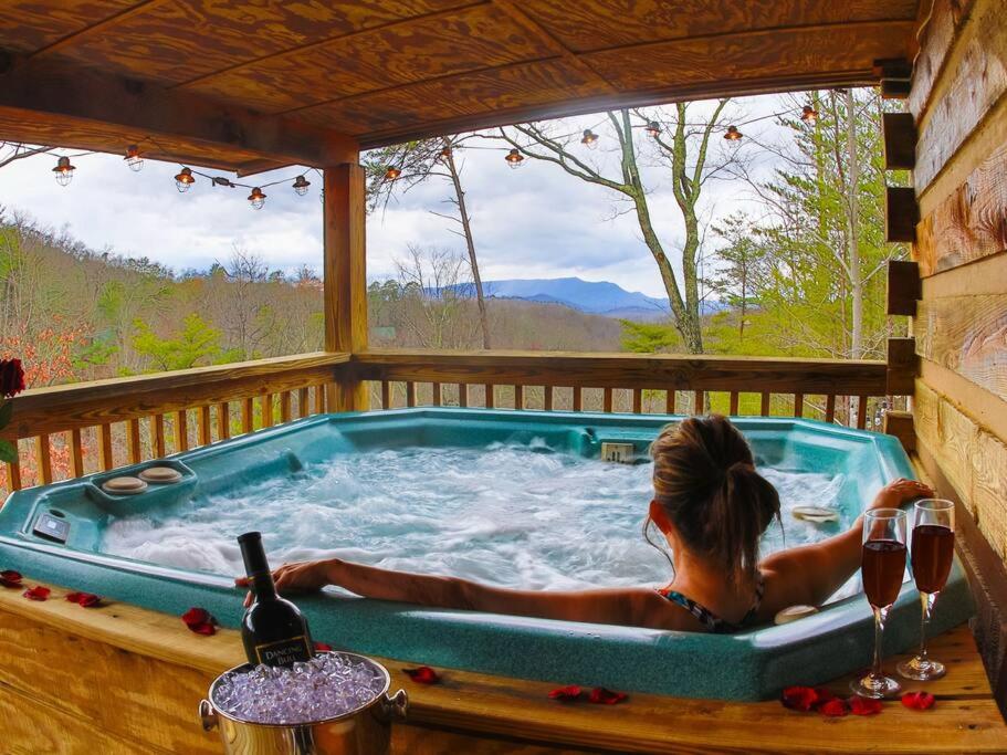 a woman sitting in a hot tub on a deck at Rustic Cabin in Sevierville