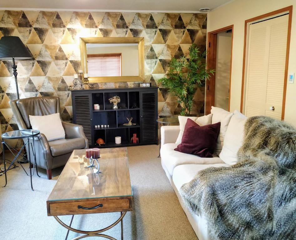 uma sala de estar com um sofá e uma mesa em Great central location, beautiful home with everything you need for a relaxing and enjoyable stay. em Palmerston North