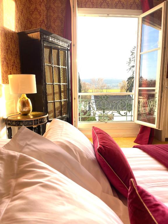 une chambre avec un lit et une fenêtre avec vue dans l'établissement Logis Hôtel & Restaurant Chateau de la Marjolaine, à Essômes-sur-Marne
