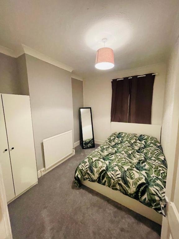 Schlafzimmer mit einem Bett und einem Spiegel in der Unterkunft Shou’s guest house in Newport