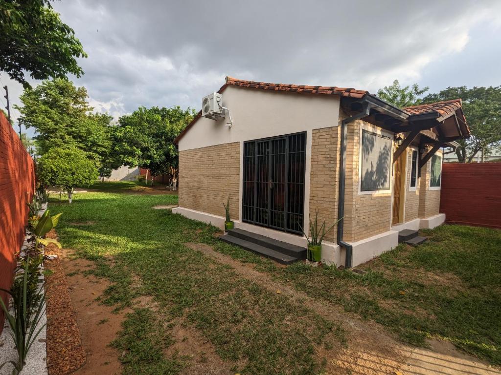 una pequeña casa con un patio delante en Casa independiente amoblada en Capiata, en Capiatá