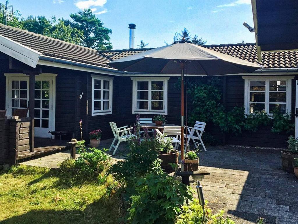 a patio with an umbrella and a table and chairs at Holiday home Græsted XXVII in Græsted