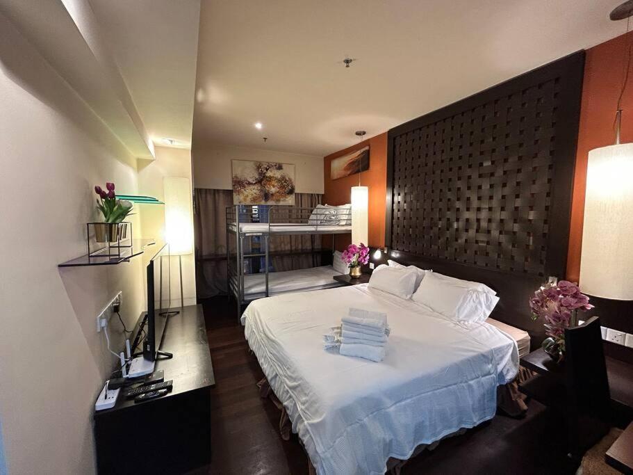 a bedroom with a large white bed and a room at SunwayLagoonFamilySuite-4-7pax-Netflix-Balcony-Super Fast Internet in Kampong Penaga