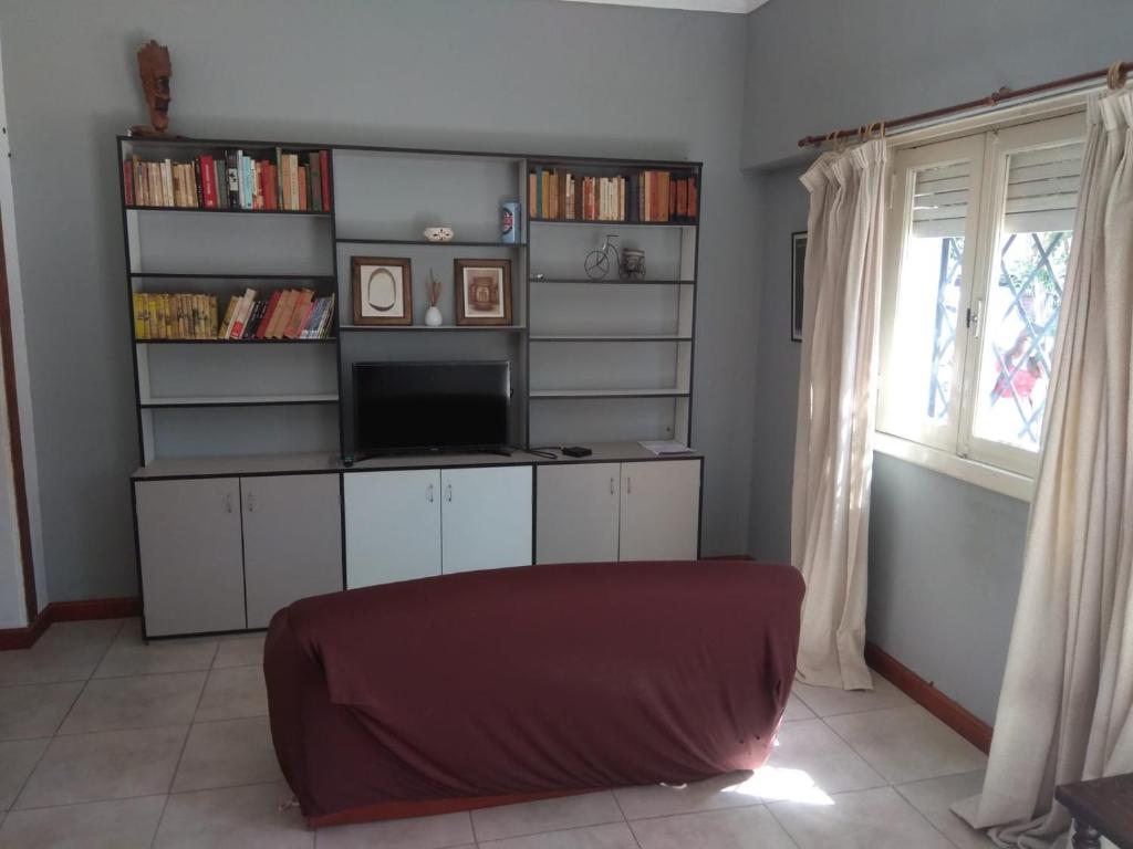 una sala de estar con TV y estanterías con libros en casa amplia, cómoda y céntrica para 5 personas en Necochea