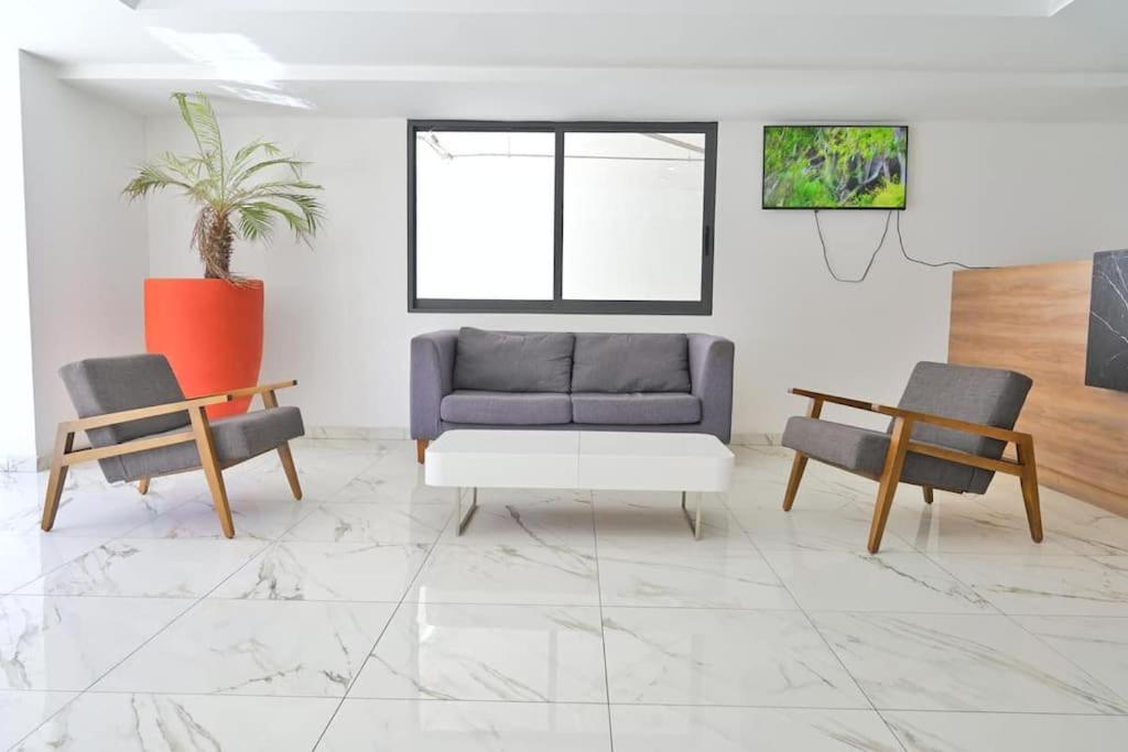 uma sala de estar com um sofá e duas cadeiras em Chapultepec Residence NEW em Guadalajara