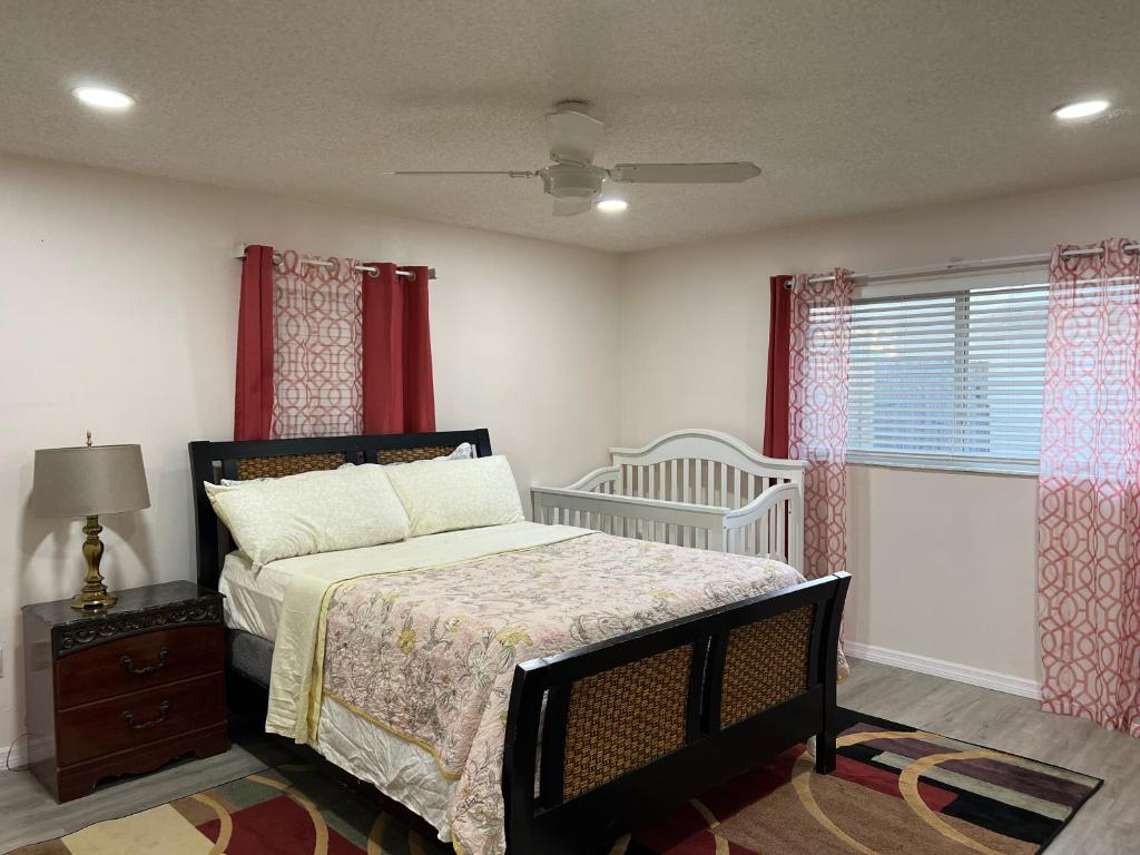 a bedroom with a bed and a crib and a window at Vacation Home 4 Bedrooms 3Baths 10 beds home in Melbourne