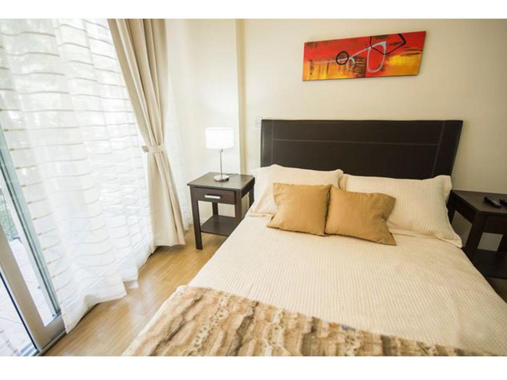 1 dormitorio con 1 cama blanca grande y 2 almohadas en Casa ivana 1 en Buenos Aires