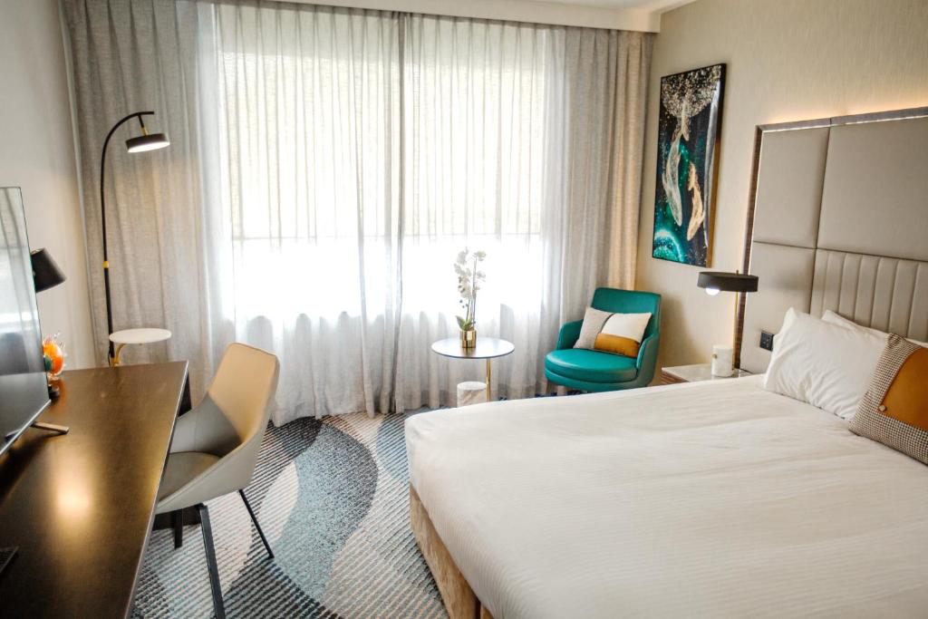 فندق روايال باسيفيك في سيدني: غرفه فندقيه بسرير ومكتب ونافذه