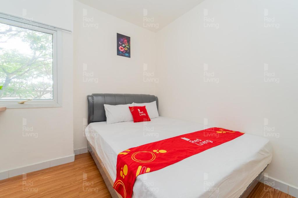 una camera da letto con un letto con una coperta rossa sopra di RedLiving Apartemen Aeropolis - Ivan Tower AR1 a Tangerang