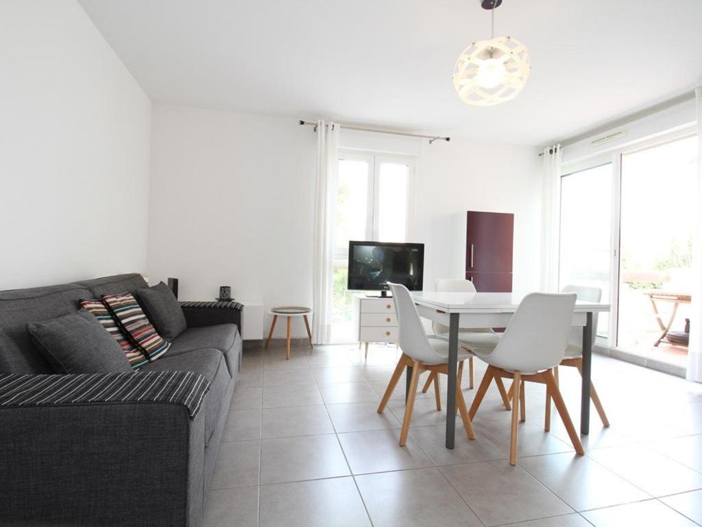 a living room with a couch and a table at Appartement T2 avec Terrasse, proche Thermes, garage et Wifi - Balaruc-les-Bains - FR-1-553-182 in Balaruc-les-Bains