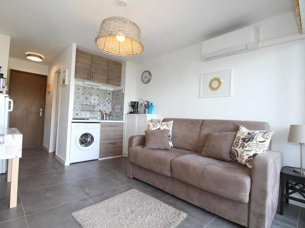 un salon avec un canapé et une cuisine dans l'établissement Charmant studio rénové avec grande terrasse, climatisation, parking privé, proche commerces et Thermes - FR-1-553-192, à Balaruc-les-Bains
