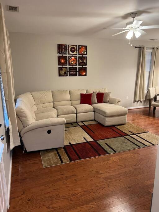 ein Wohnzimmer mit einer weißen Couch und einem Teppich in der Unterkunft Cheerful 3 bedroom, close to downtown and arena!!! in Savannah