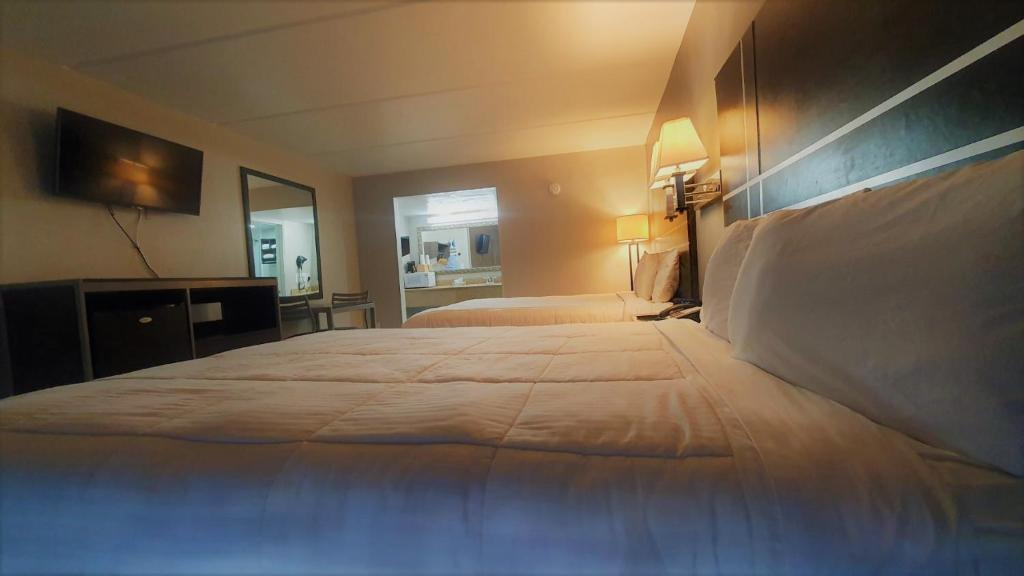 ein Hotelzimmer mit einem großen Bett und einem Spiegel in der Unterkunft South Padre Island Lodge in South Padre Island