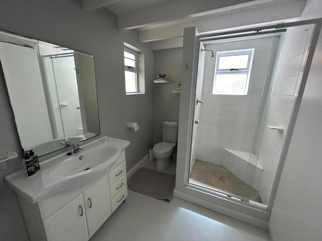 a bathroom with a toilet and a sink and a shower at Cozy Corner Cottage in Langebaan