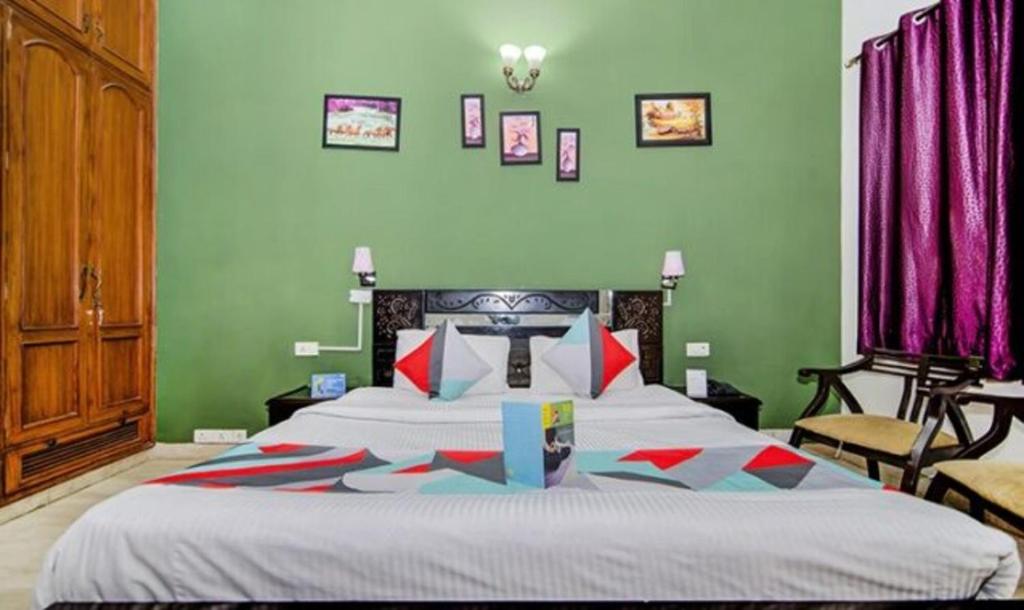 ein Schlafzimmer mit einem großen Bett mit grünen Wänden in der Unterkunft FabExpress Ashray in Noida