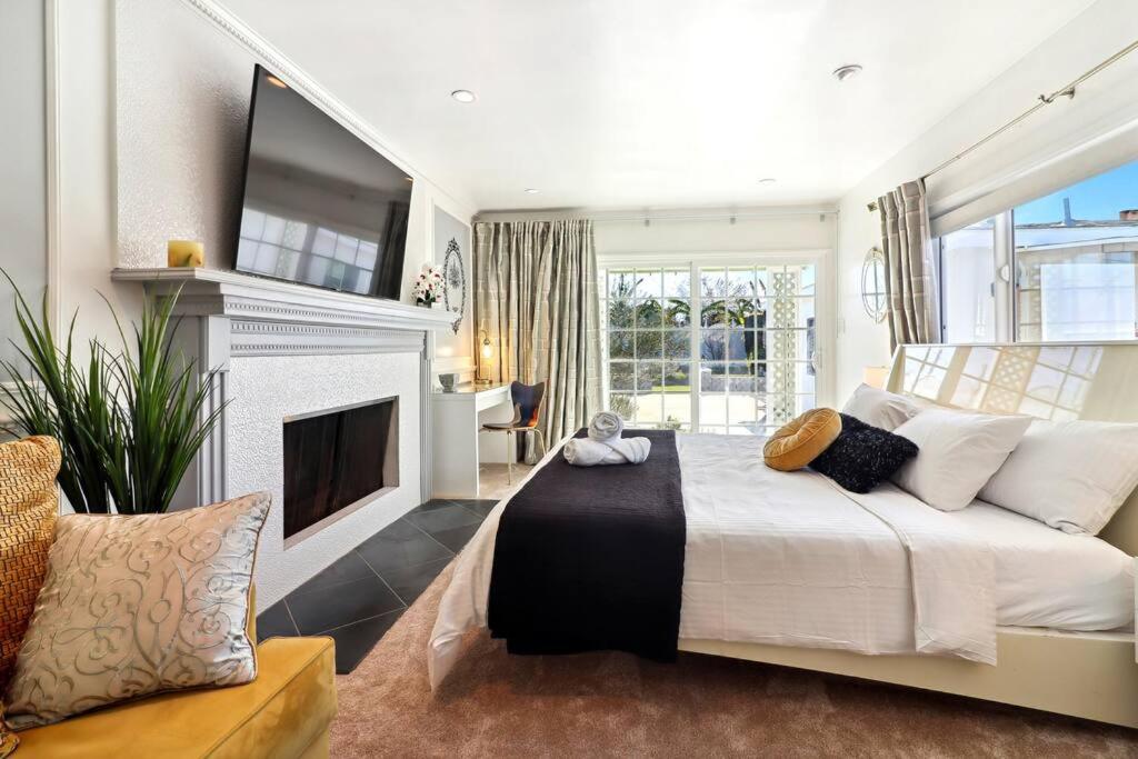 a bedroom with a large bed and a fireplace at Luxury Home - 7mins LAX/Beach, 405/SoFi nearby in Hawthorne