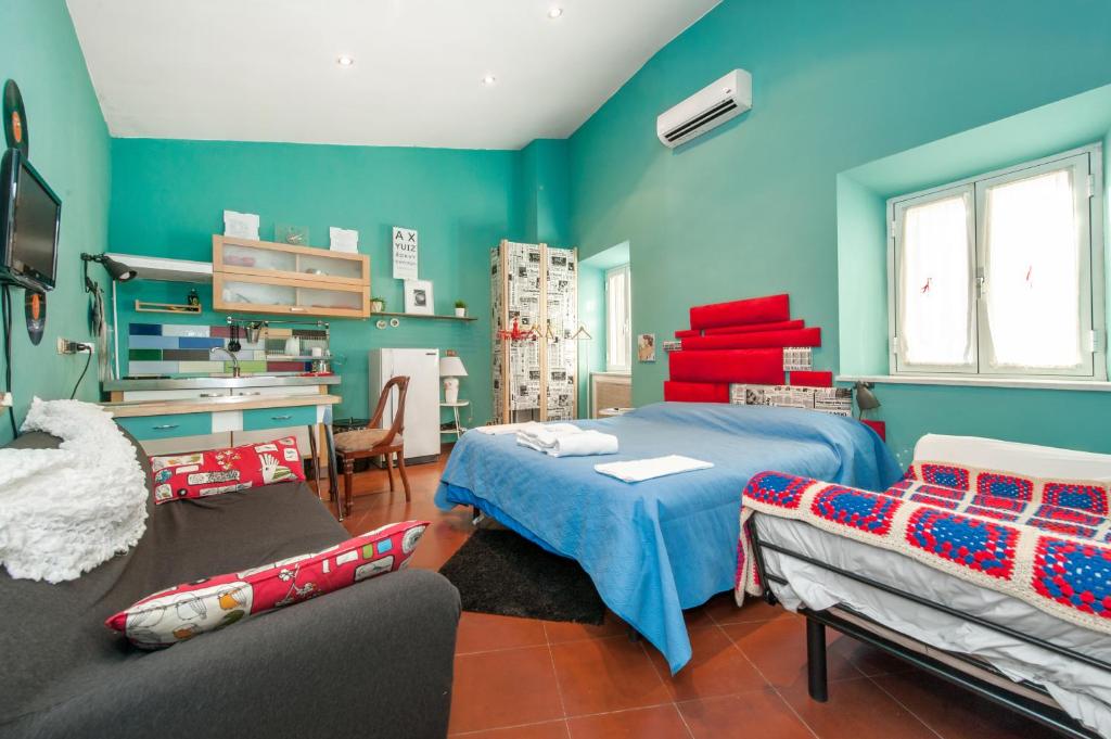 a bedroom with blue walls and a bed and a couch at Signor Suite Colosseo in Rome