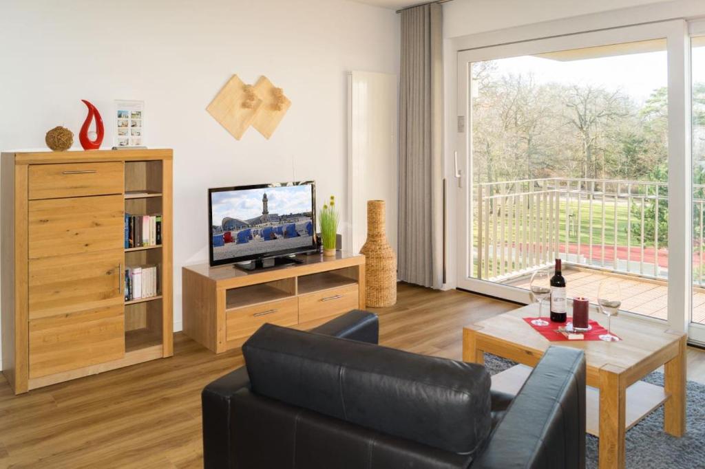 sala de estar con sofá y TV en Residenz/Eric, en Warnemünde